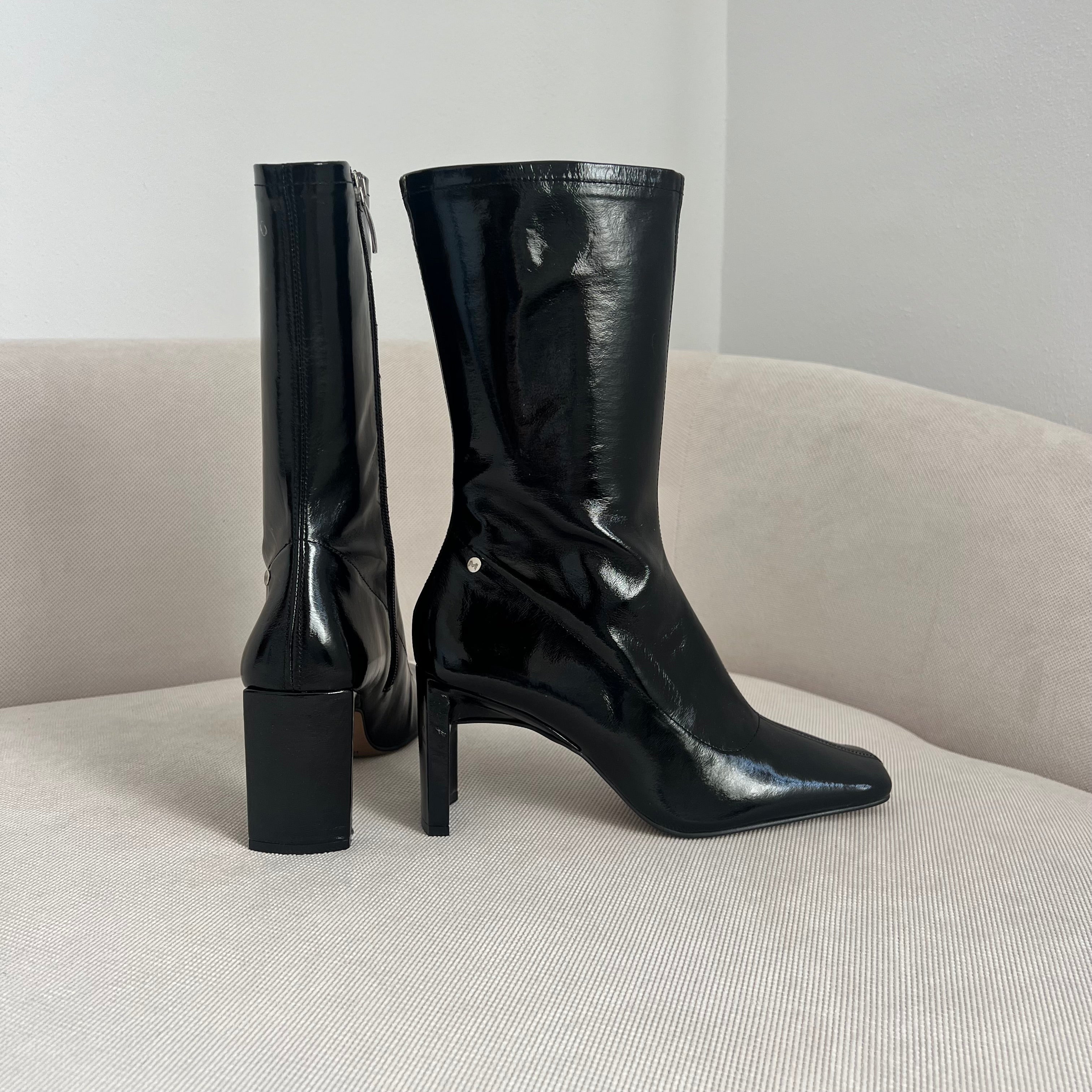 Detalle lateral del botín PIZZO BLACK, mostrando textura brillante y elegantemente curvada.